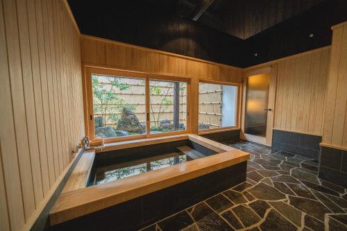 TakahashiCastle Town Contemporary Ryokan 天籟 - TENRAI -的一个带窗户的客房内的按摩浴缸