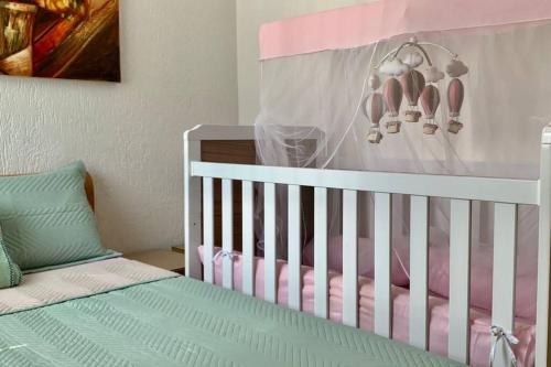 巴西利亚3 Quartos Melhor Valor do Df próximo ao Aeroporto e Plano的一张带粉红色和白色婴儿床的婴儿床