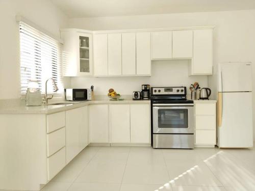 Clifton FallsThe Willow Apartment的白色的厨房配有白色橱柜和冰箱。