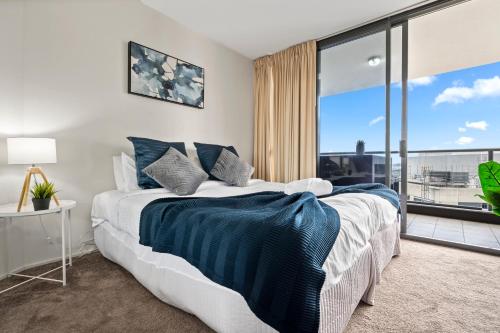 布里斯班Brisbane Break Panoramic River Views Free Parking的一间卧室设有一张大床和一个大窗户