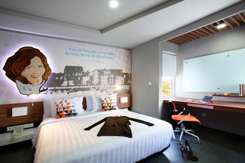 塞米亚克Berry Biz Hotel Sunset Road的卧室配有一张大床,墙上挂着一幅画