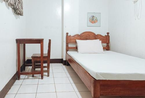 Colonia Parcela Number OneRedDoorz @ Grand Valley Hotel Junction Luna Cagayan的一间卧室配有两张床、一张桌子和一把椅子