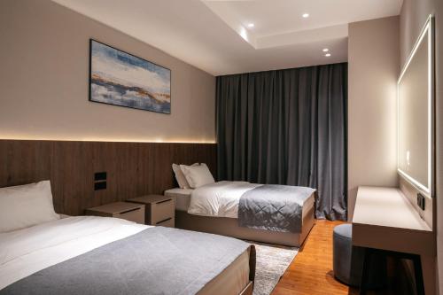 阿拉木图Raavah Aparthotel的酒店客房设有两张床和窗户。