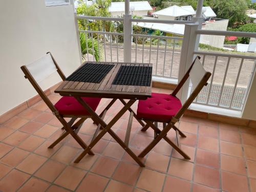 拉特里尼泰CLANES LOCATION Acerola的阳台配有一张桌子和两把椅子以及一台笔记本电脑