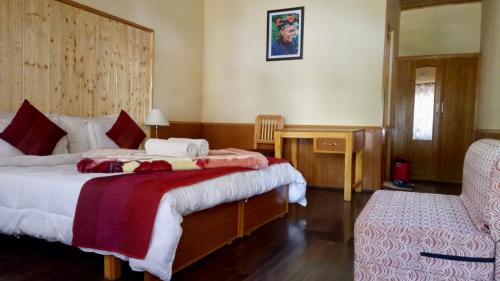 列城Chamba resort的一间卧室配有两张床、一张桌子和一把椅子