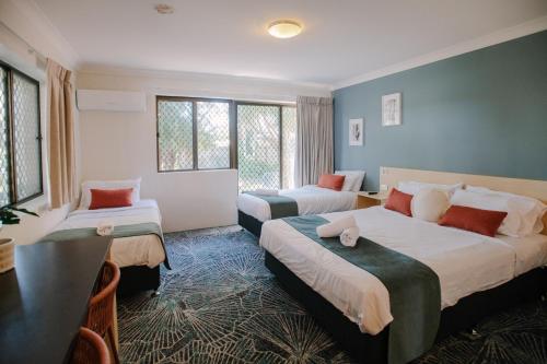 贝尔拉拉Bribie Island Hotel的酒店客房设有两张床和一张桌子。