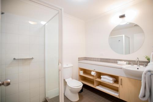 贝尔拉拉Bribie Island Hotel的一间带卫生间、水槽和镜子的浴室