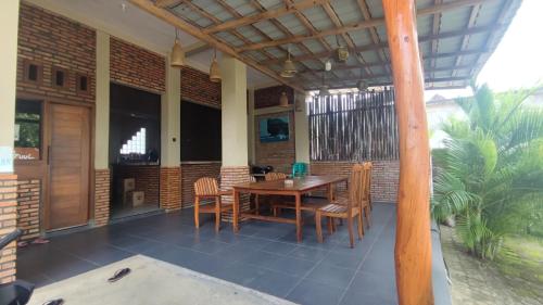 巴芝丹Bintang Homestay Watukarung的房屋内带木桌和椅子的庭院