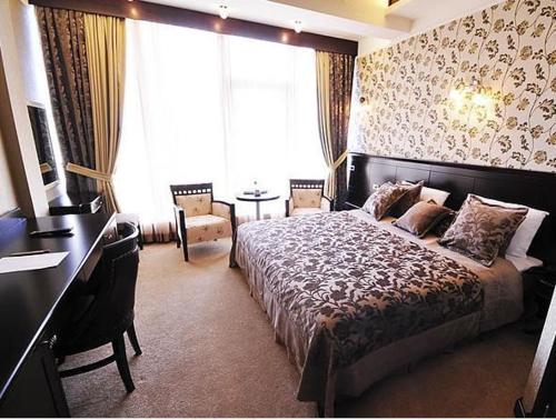 巴库里维埃拉酒店的一间卧室配有一张床、一张书桌和一个窗户。