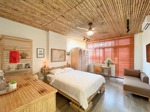 胡志明市Song Anh Indochina Studios Nguyen Thai Binh的一间卧室配有一张床、一张沙发和一把椅子