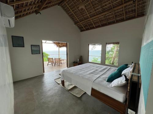 Nosy KombaCanopee Lodge的一间卧室设有一张床,享有海景
