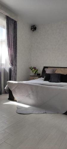 阿尔兹尼Дом с красивым видом的卧室配有一张白色大床