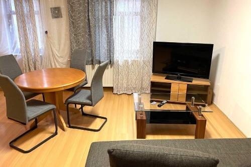 KahlaCity apartment with Wifi near Jena的客厅配有桌子和平面电视。