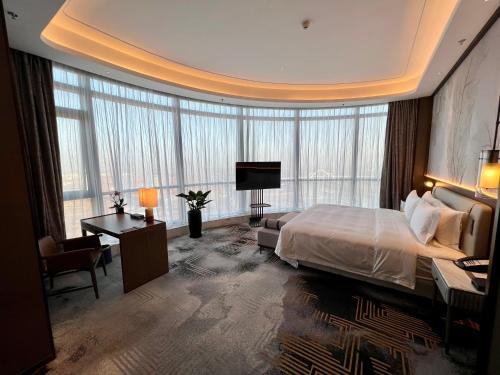 太原山西潇河新城温德姆酒店(潇河国际会议中心店)的酒店客房设有一张大床和一张书桌。