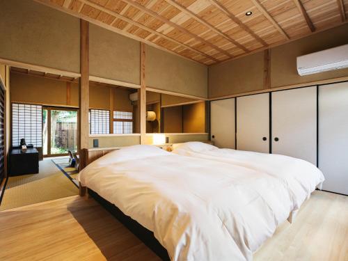 YameRITA Yame Fukushima的一间卧室设有一张带木制天花板的大床