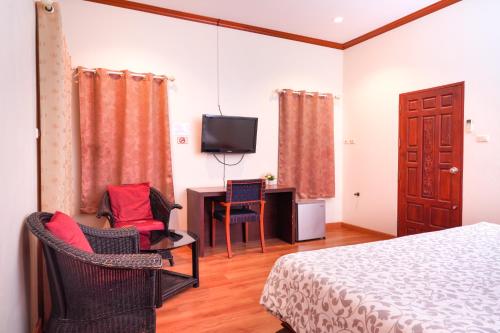 Ban Bo HanGuesthouse Phuket Airport的一间卧室配有一张床、一张书桌和一台电视。