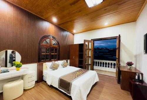 Trai MatDalat Eco House的一间卧室配有一张床、一张书桌和一个窗户。
