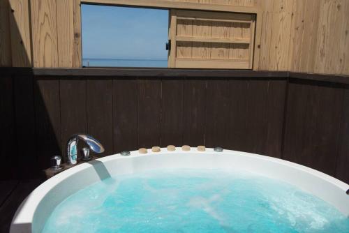 出云市Jikukan Mukae的浴室设有蓝色水浴缸