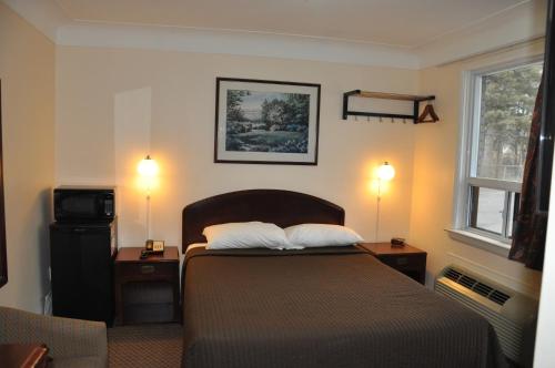 伯灵顿皇家酒店的一间卧室配有一张带2个床头柜和2盏灯的床。