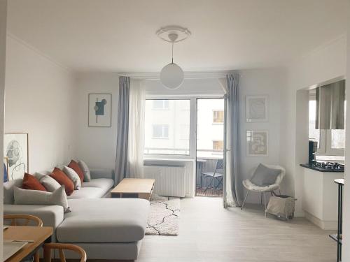 哥本哈根An cosy apartment near CPH airport的白色的客厅配有沙发和桌子