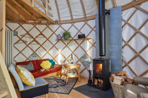 NitonPuckaster Cove Luxury Yurt的蒙古包内带炉灶的客厅