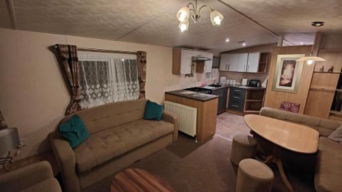 LincolnshireBUTLINS SKEGNESS, 3 Beds, Pet Friendly - The Paddock的带沙发和桌子的客厅以及厨房。