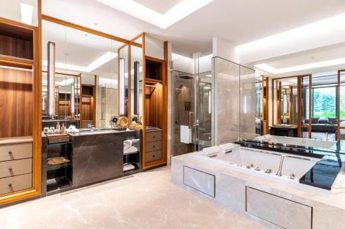 曼谷Villa Deva Resort & Hotel Bangkok的一间带大浴缸和淋浴的浴室