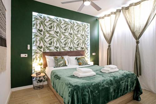 洛斯克里斯蒂亚诺斯Royal Suite Diamantes I With heated pool的绿色卧室,配有带毛巾的床