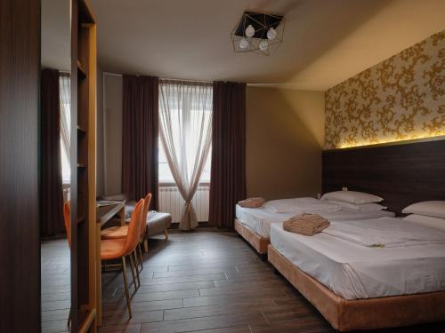 维罗纳Hotel Giulietta的酒店客房配有两张床和一张书桌