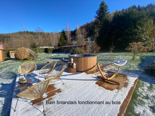 普兰凡Gîte Chalet avec bain nordique et piscine 11 pers Hautes Vosges的坐在火坑周围的椅子