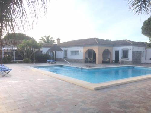 加的斯Villa Torrealta, 4000 m2, estancia mínima en verano 7 días de sábado a sábado的房屋前的大型游泳池