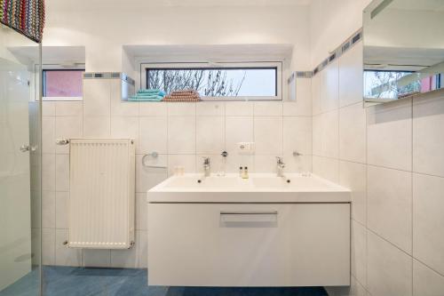 慕尼黑Haus Rose Muc City的白色的浴室设有水槽和窗户。