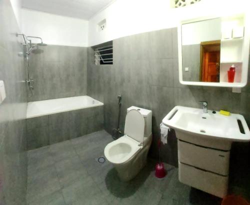 基加利BIZI HOMES的浴室配有盥洗盆、卫生间和浴缸。
