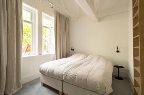 东弗利兰Appartement N05 Bakboord & Stuurboord的白色的卧室设有床和窗户