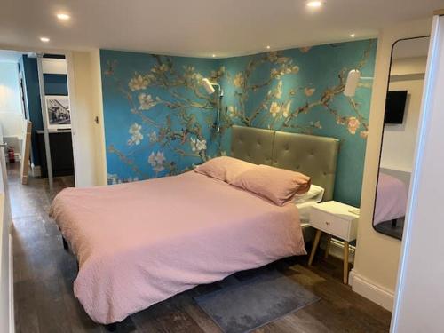 萨德伯里Number One High Street Clare的一间卧室设有一张大床和蓝色的墙壁