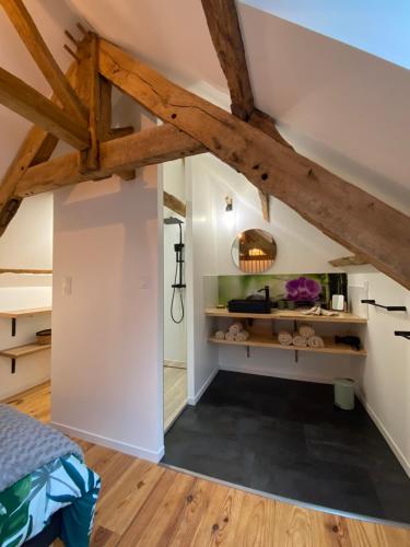 Saint-Malon-sur-MelA la Mémoire de Merlin & SPA的卧室拥有白色的墙壁和木梁。