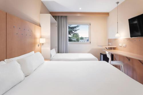阿尔甘达·德尔·雷伊B&B HOTEL Madrid Arganda的酒店客房设有两张床和窗户。