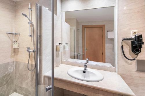 阿尔甘达·德尔·雷伊B&B HOTEL Madrid Arganda的浴室配有盥洗盆和带镜子的淋浴
