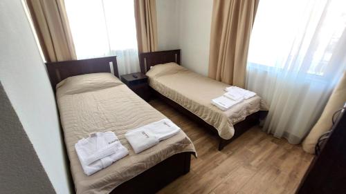 巴尼亚Къща за гости - Вила Сидона的两张位于酒店客房的床,配有毛巾