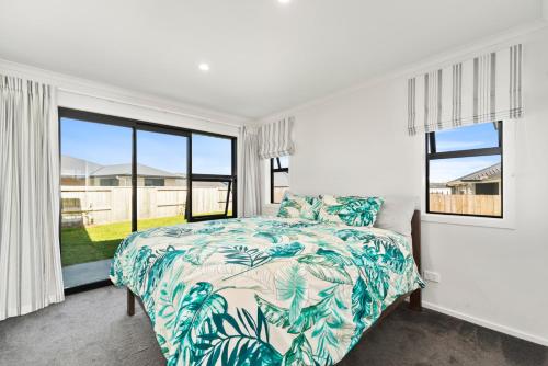 陶波Puna Rise - Taupo Holiday Home的一间卧室设有一张床和一个大窗户