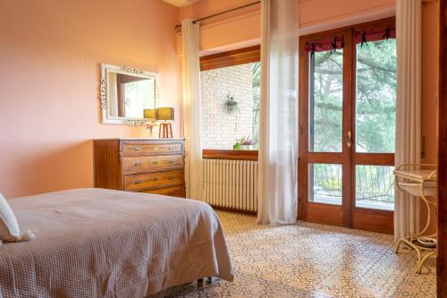 蒙特普齐亚诺波利赞那圣贝别墅的一间卧室配有一张床、一个梳妆台和一扇窗户。
