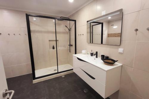 沙尔内卡Casa Borges的带淋浴、盥洗盆和镜子的浴室