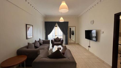 科威特科威特公寓的客厅配有两张沙发和一台电视机