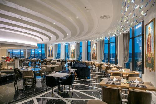 兹拉蒂博尔A Hoteli - Grand&Sky Hotel Tornik的餐厅设有桌椅和窗户。
