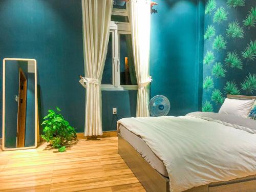 大叻摩卡之家（背包客）旅舍的一间拥有蓝色墙壁的卧室和一张带镜子的床