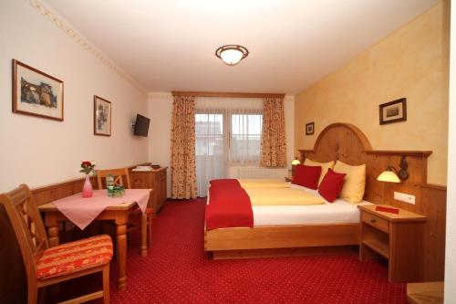 斯拉德明加尼兰德豪斯特勒肯巴赫酒店的酒店客房设有一张大床和一张桌子。