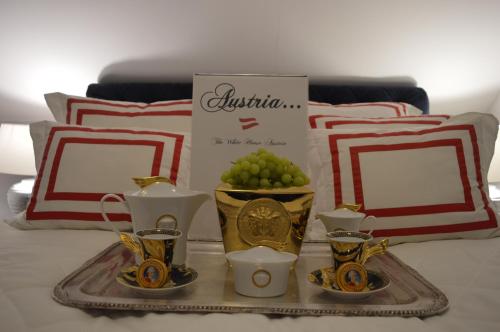 Lind ob Velden白宫奥地利公寓的床上装有花瓶和杯子的托盘