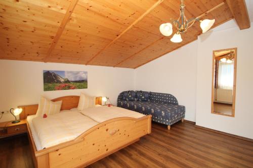 菲根贝格奥博姆斯霍夫酒店的一间卧室配有一张木床和一张沙发