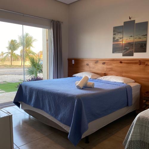图托亚Pousada Delta Village的一间卧室配有一张带蓝色毯子的床