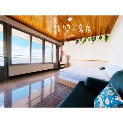 Dongshi星森林包棟住宿-台中東勢-山區景觀的一间卧室配有一张床、一张沙发和窗户。